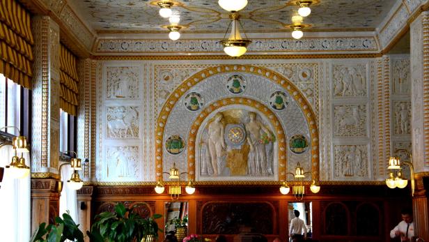 Das kunstvoll dekorierte Interieur eines Cafés mit Gästen an Tischen.