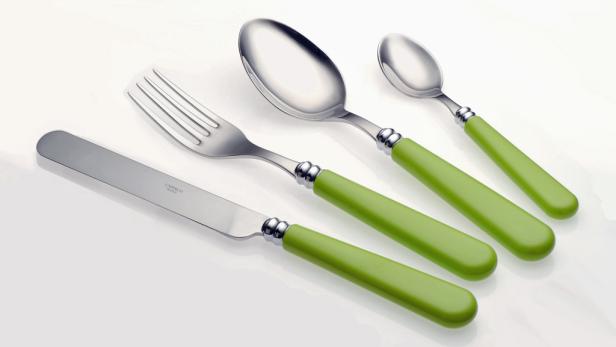 Ein Set aus Messer, Gabel, großem Löffel und kleinem Löffel mit hellgrünen Griffen liegt auf einem Tisch.