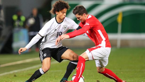 Zwei Fußballspieler im Zweikampf auf dem Spielfeld.