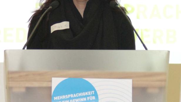 Dinah D. steht an einem Rednerpult bei der Veranstaltung „Sag’s Multi!“.