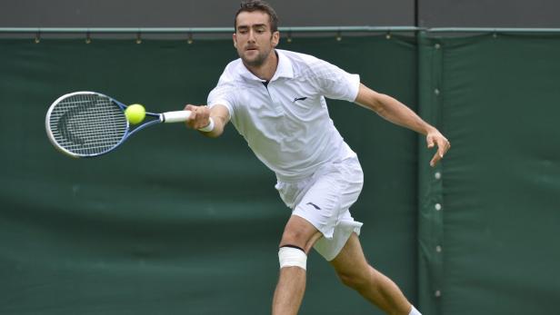 Marin Cilic of Croatia hits a return to Marcos Baghdatis of Cyprus in their men&#039;s singles tennis match at the Wimbledon Tennis Championships, in London June 24, 2013. Picture taken June 24, 2013. REUTERS/Toby Melville (BRITAIN - Tags: SPORT TENNIS)