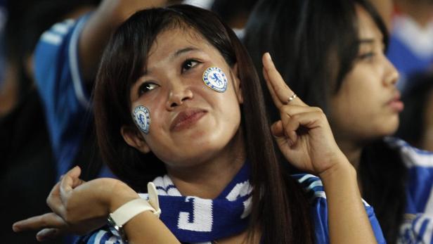 A woman wearing Chelsea stickers poses for a photograph during a friendly match between Chelsea and Indonesia all stars at Gelora Bung Karno Stadium, in Jakarta July 25, 2013. Chelsea is in Indonesia for a three-day visit as part of their Asia Tour. REUTERS/Enny Nuraheni (INDONESIA - Tags: SPORT SOCCER)