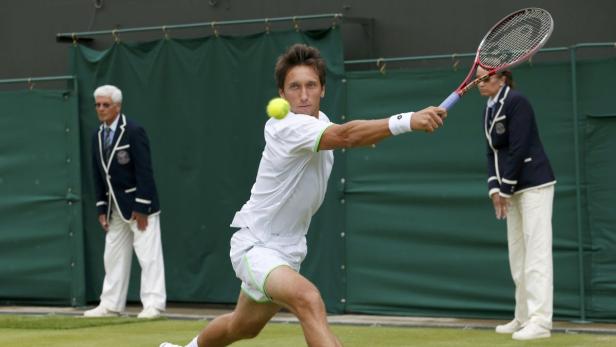 Ein Tennisspieler schlägt einen Ball während eines Matches in Wimbledon.