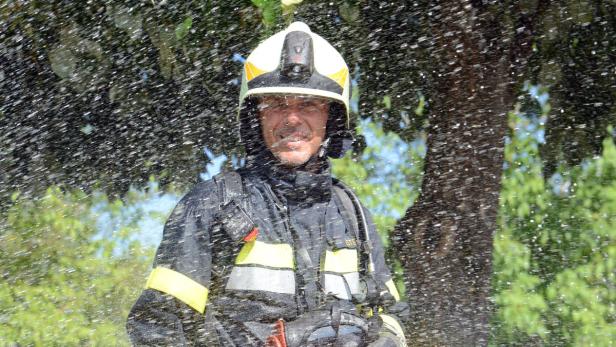 17.07.2013: Kommandant der FF Ferlach, Hans Esterle, 46, nur fürs Foto im Sprühregen eines Löschschlauches