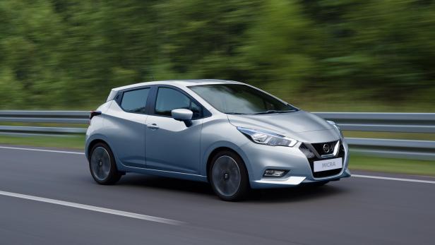 Ein silberner Nissan Micra fährt auf einer Straße.