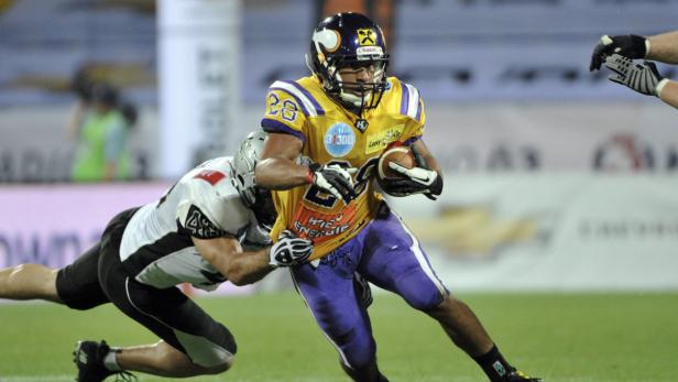 Ein American-Football-Spieler wird von einem Gegenspieler angegangen.