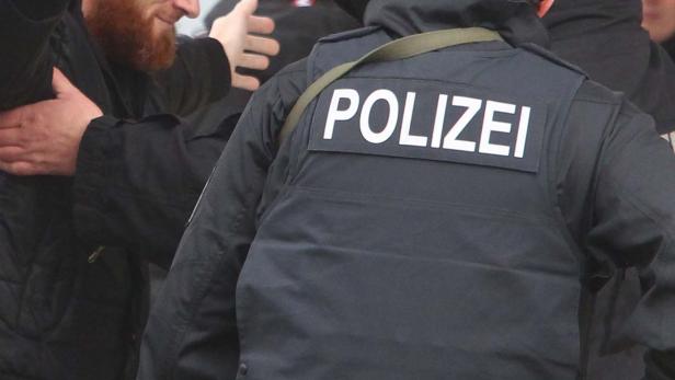 Ein Polizist in Uniform steht in einer Menschenmenge.
