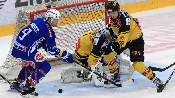 Eishockeyspieler kämpfen vor dem Tor um den Puck.