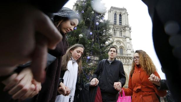 Gedenkminute Donnerstag Mittag vor Notre-Dame: Der Platz ist im strömenden Regen gefüllt, nur das Läuten der Kathedrale im Herzen von Paris durchbricht die Stille.