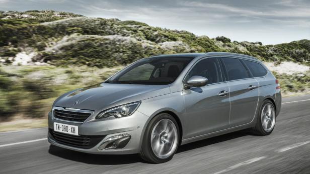 Ein silberner Peugeot 308 SW fährt auf einer Landstraße.