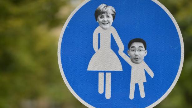Blick am 23.09.2013 in Berlin Mitte auf ein verfremdetes Straßenschild, welches das Verhältnis von Bundeskanzlerin Angela Merkel (CDU) und Wirtschaftsminister Philipp Rösler (FDP) karikiert. Foto: Bernd von Jutrczenka / dpa +++(c) dpa - Bildfunk+++