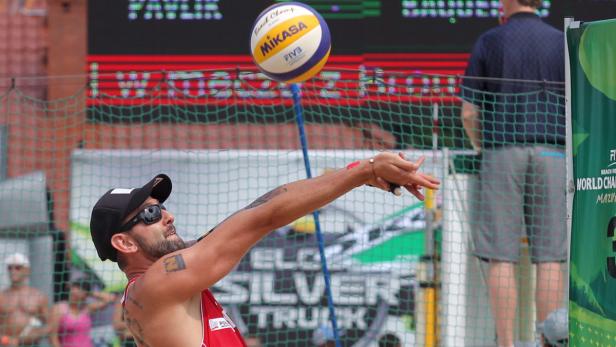 Ein Beachvolleyballspieler schlägt einen Mikasa-Ball beim Aufschlag.