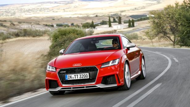 Ein roter Audi TT fährt auf einer kurvenreichen Straße.