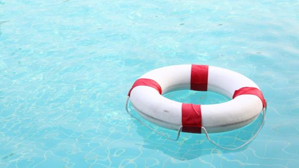 red and white rescue wheel on swimming pool