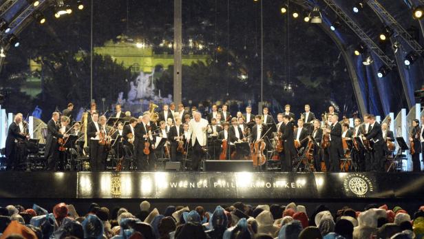 Die Wiener Philharmoniker treten vor einem Publikum im Freien auf.