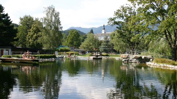 Gloggnitz,_Naturbad_ cc sa by Steindy.jpg Ein ruhiger Badesee mit Badegästen und einem Kloster im Hintergrund.