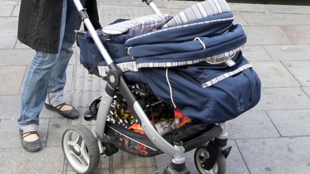 Ein Kinderwagen steht auf einem Bürgersteig.