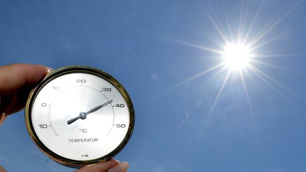 Ein Thermometer zeigt eine hohe Temperatur vor einem strahlend blauen Himmel.