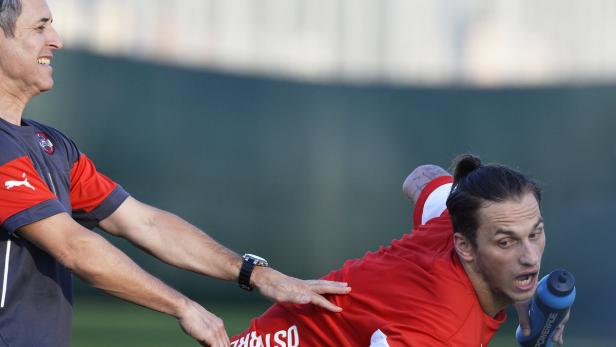 Ein Fußballspieler wird während des Trainings von einem Trainer korrigiert.