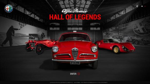 Verschiedene rote Alfa Romeo Oldtimer in einer Halle unter dem Schriftzug „Hall of Legends“.