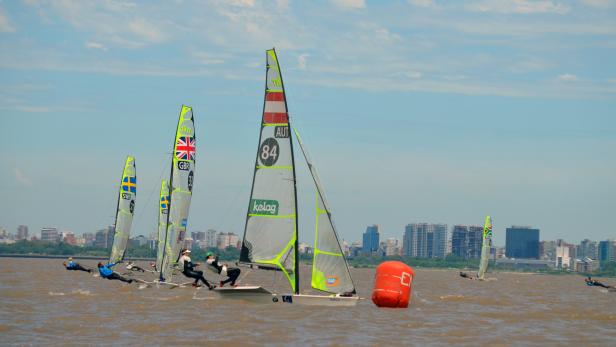 Mehrere 49er-Segelboote mit Segeln unter anderem mit den Flaggen von Großbritannien, Schweden und Österreich auf dem Wasser.