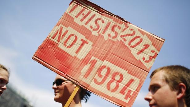 A protester holds a placard reading &quot;This is 2013, not 1984&quot; during a demonstration against the National Security Agency (NSA) and in support of U.S. whistleblower Edward Snowden in Frankfurt, July 27, 2013. Protests across Germany have gained following the leaking of the NSA intelligence agency&#039;s monitoring of international internet traffic and about 2,000 people took part in the demonstration. REUTERS/ Kai Pfaffenbach (GERMANY - Tags: POLITICS CIVIL UNREST CRIME LAW)