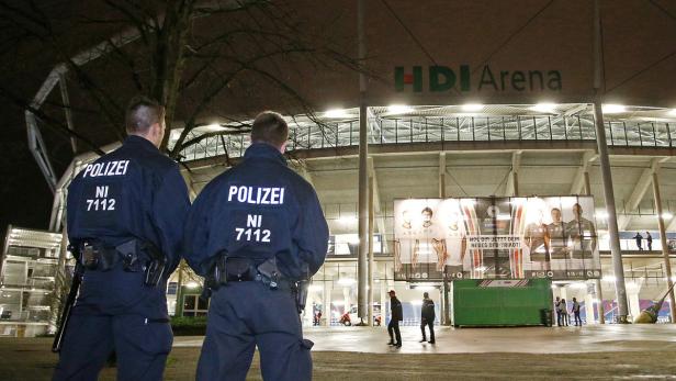Zwei Polizisten stehen vor der HDI-Arena in Hannover.