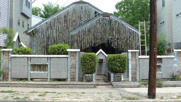 Ein Haus und ein Zaun, verziert mit unzähligen Flaschen und Dosen.
