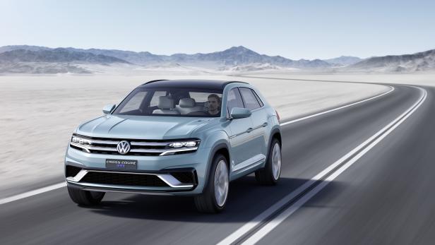Ein hellblauer VW Cross Coupé GTE fährt auf einer Straße durch eine Wüstenlandschaft.