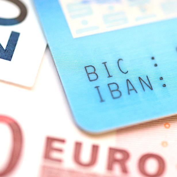 Nahaufnahme von Euroscheinen und einer Bankkarte mit IBAN und BIC.