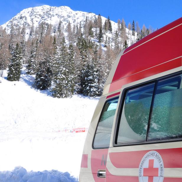 Ein Rettungswagen des Österreichischen Roten Kreuzes steht im Schnee vor einer Berglandschaft.