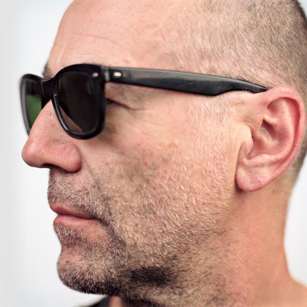 Ein Mann mit Sonnenbrille, von der Seite aufgenommen.
