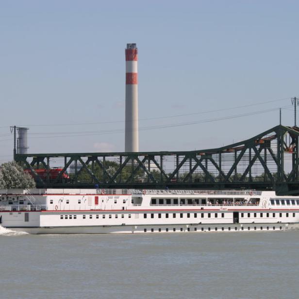 Ein Passagierschiff fährt auf die Ostbahnbrücke zu.