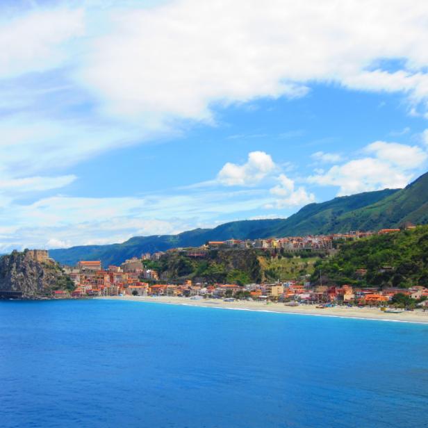 Blick auf Scilla in Kalabrien mit dem Castello Ruffo auf einem Felsen im Meer.
