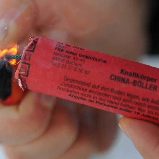 Eine Person zündet einen „China-Böller D“ Feuerwerkskörper an.
