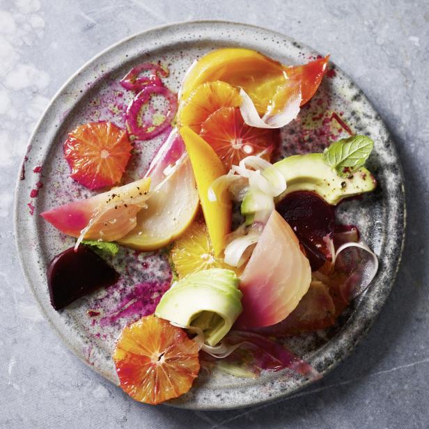 Ein Teller mit einem bunten Salat aus Orangen, Avocado und Bete.