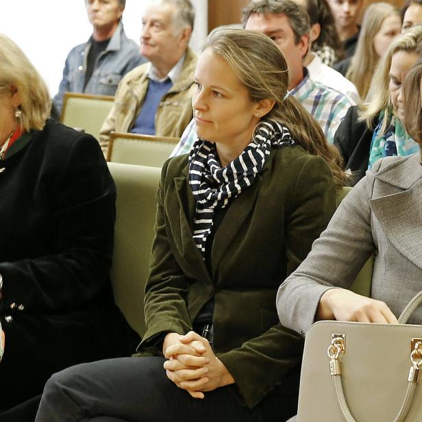 Drei Frauen sitzen in einer Reihe während einer Veranstaltung.