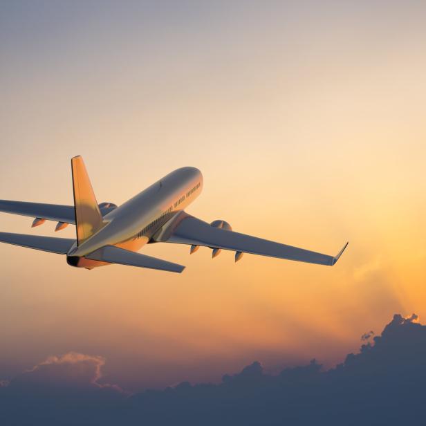 Ein Flugzeug hebt bei Sonnenuntergang ab.