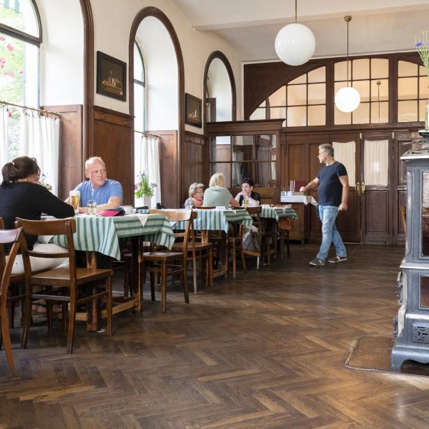 In einem traditionellen Restaurant sitzen mehrere Personen an Tischen.