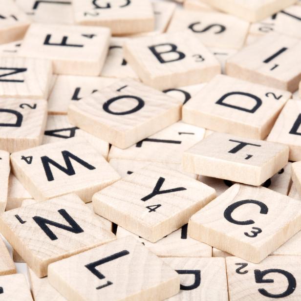 Nahaufnahme von hölzernen Scrabble-Buchstabensteinen.