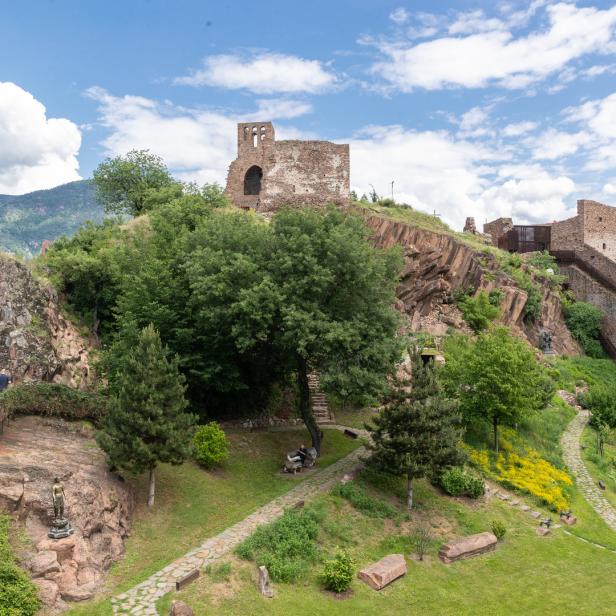 Blick auf Schloss Runkelstein in Bozen mit seinen Mauern und Türmen auf einem Hügel.