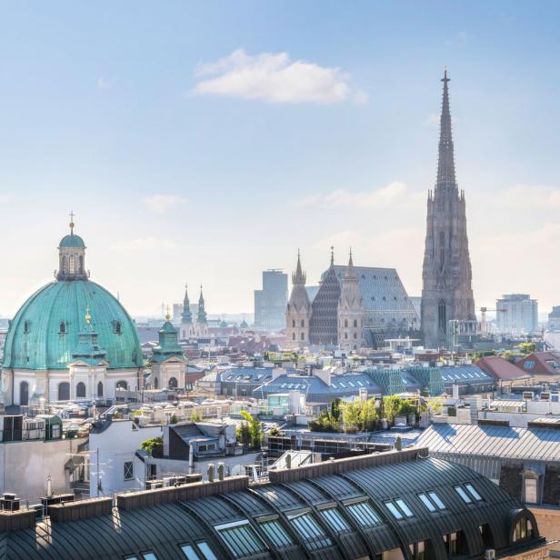 Die Skyline von Wien zeigt den Stephansdom und andere historische Gebäude unter blauem Himmel.