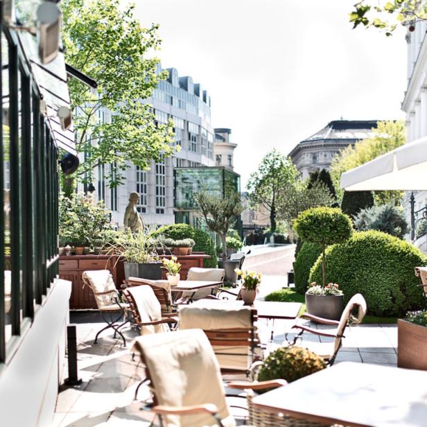 Einladende Terrasse eines Cafés mit Tischen und Stühlen im Freien.