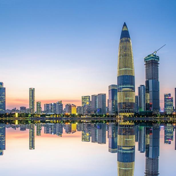 Die Skyline von Shenzhen spiegelt sich im ruhigen Wasser bei Dämmerung.