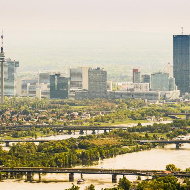 Ein Panoramablick auf Wien mit der Donau und der Skyline im Hintergrund.