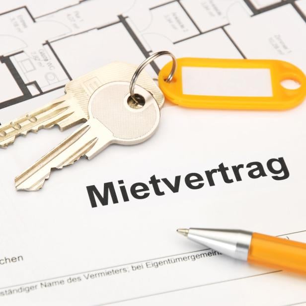 Ein Mietvertrag liegt mit Schlüsseln und einem Stift auf einem Tisch.