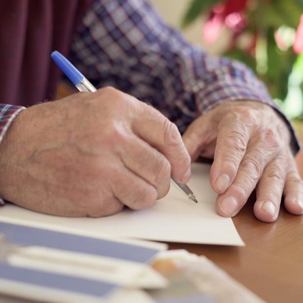 old man writing christmas cards