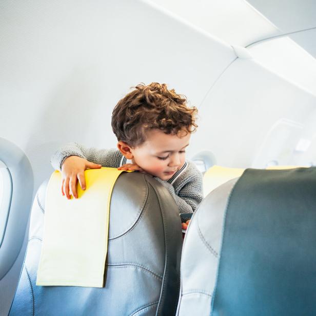 Boy playing with toy plane in airplane