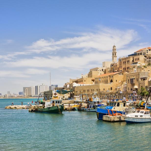 Blick auf den Hafen von Jaffa mit Fischerbooten und der Altstadt im Hintergrund.