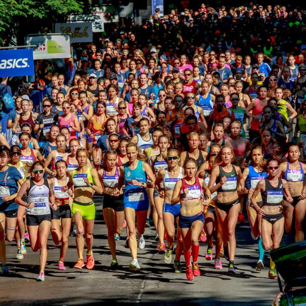Eine große Gruppe von Frauen nimmt an einem Straßenlauf teil.